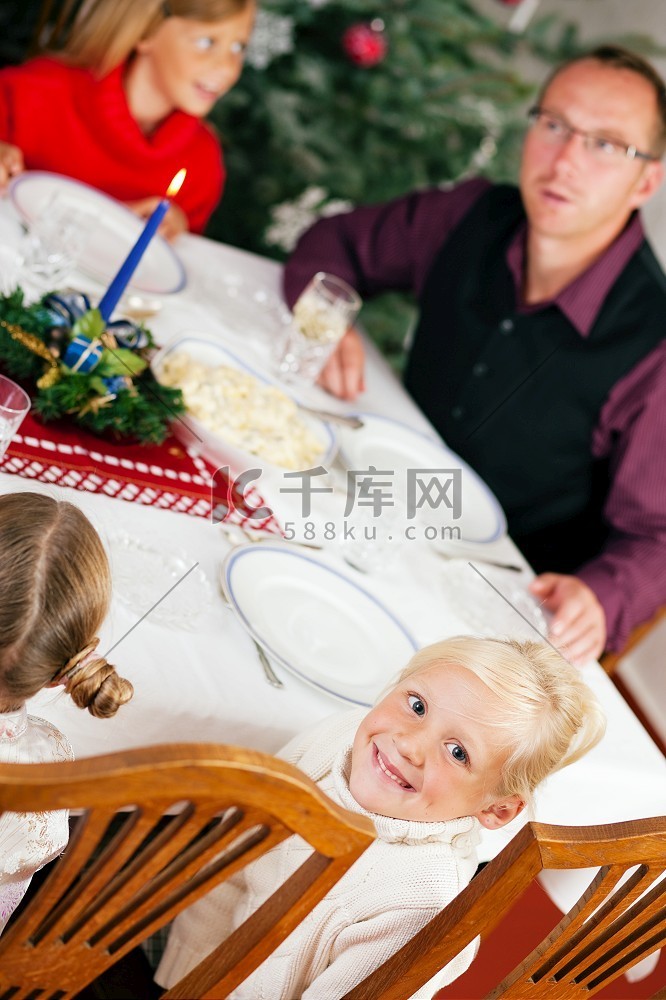 一家人在圣诞树前吃传统的圣诞晚