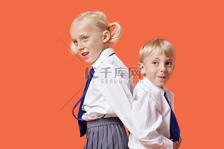快乐的年轻男孩和女孩校服站在背