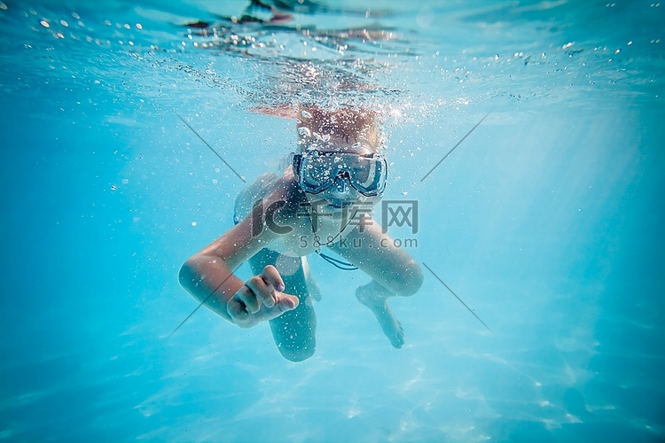 男孩在游泳池里的水下游泳