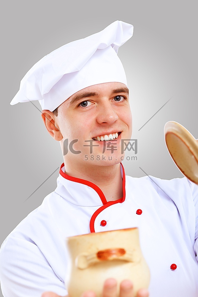 穿着红色围裙的年轻男厨师在灰色