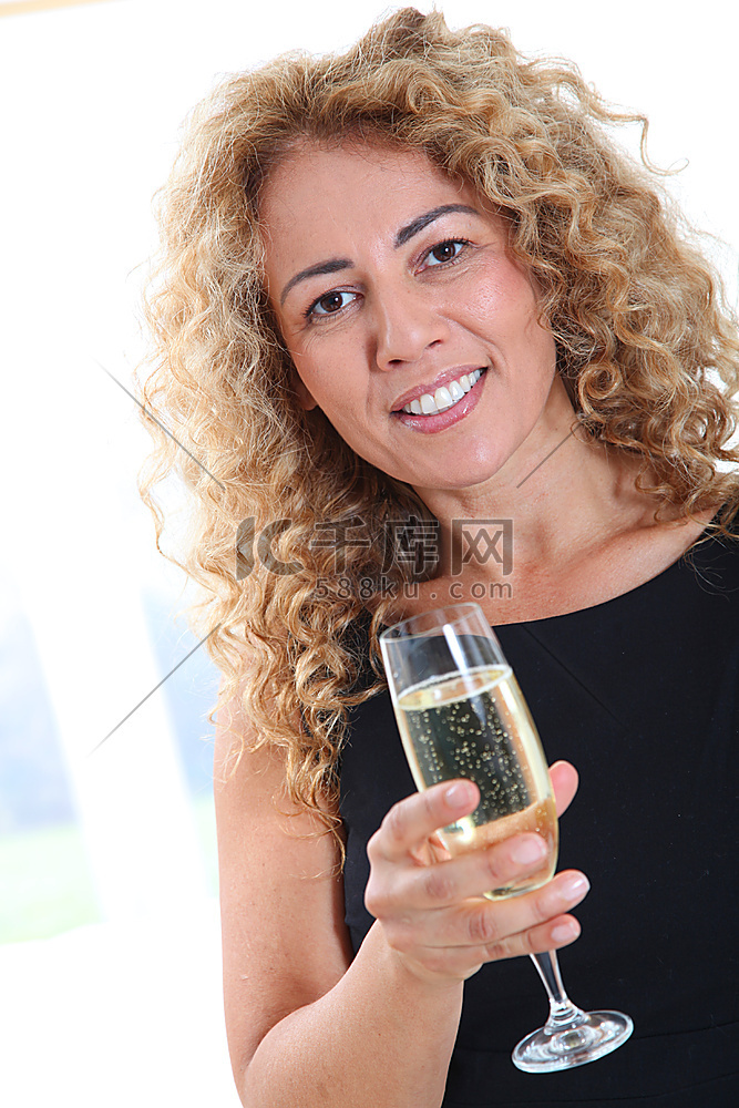 一位微笑的金发女子拿着香槟