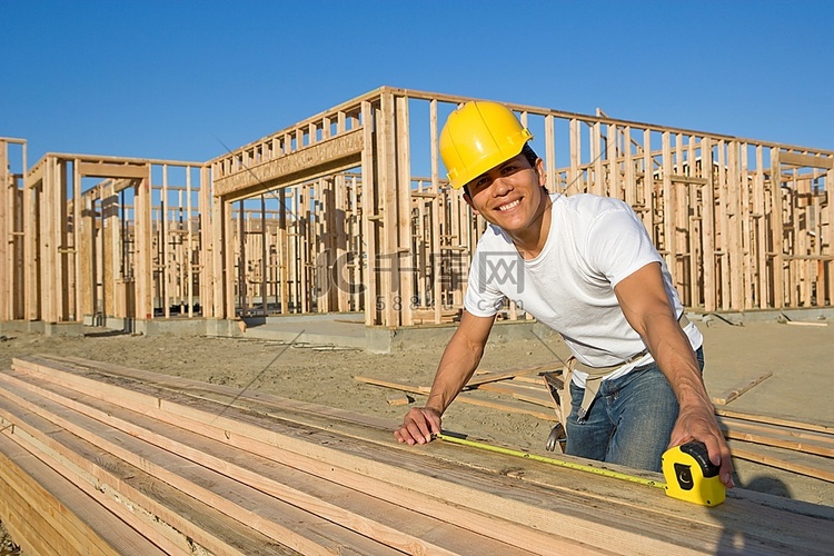 建筑工人测量木板尺寸
