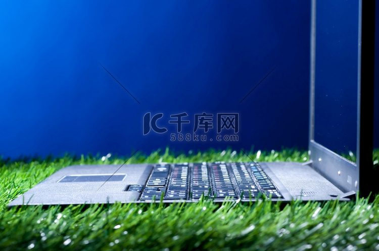 草地上的现代笔记本电脑在黑暗中