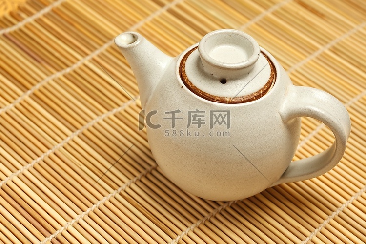 竹席上的茶壶特写照片