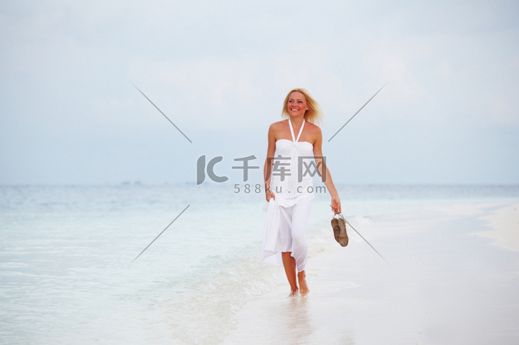 一位穿着白色连衣裙的女人在海边