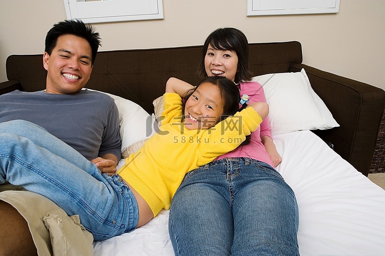 母亲、父亲和女儿躺在床上放松