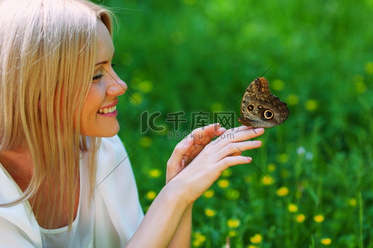 妇女玩一只蝴蝶在绿草