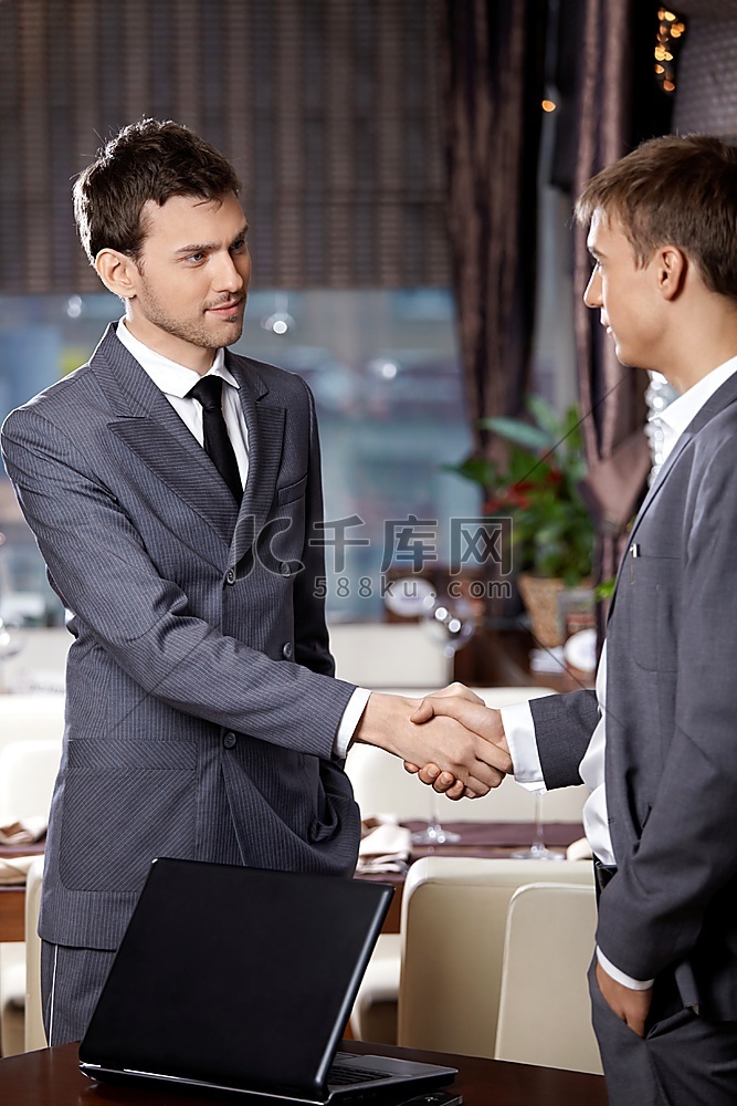 两位商人在餐厅的一次会议上握手