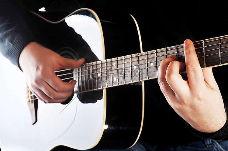 一位弹吉他的音乐家的双手特写