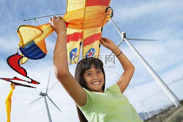 女孩(7-9岁)在风电场拿着飞机风筝