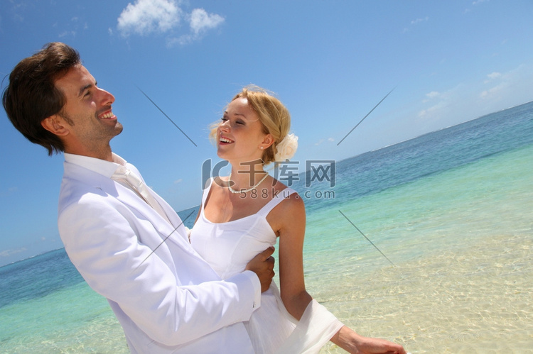 新娘和新郎在蓝色泻湖边跳舞