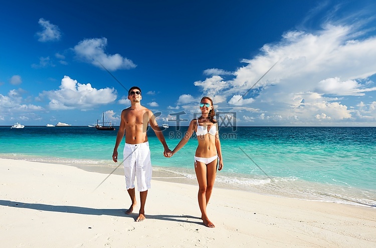 一对夫妇在马尔代夫的热带海滩上