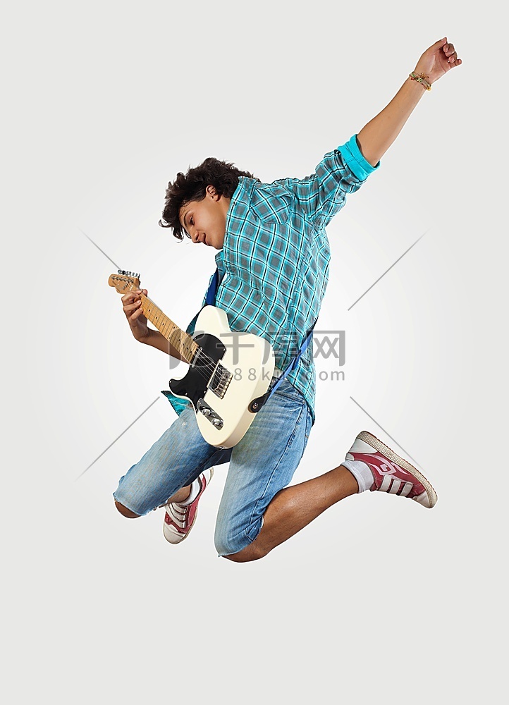 年轻人玩电吉他和跳跃