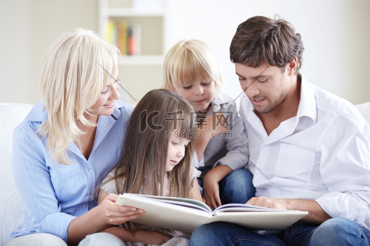 年轻的父母正在读一本适合幼儿阅
