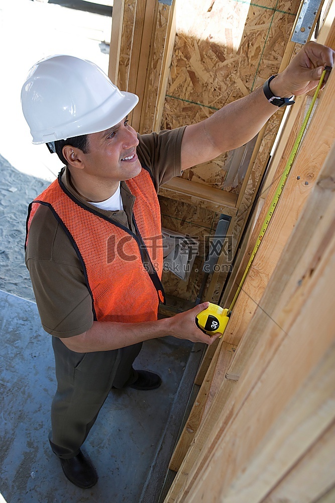 建筑工人在半建成的房屋内测量带