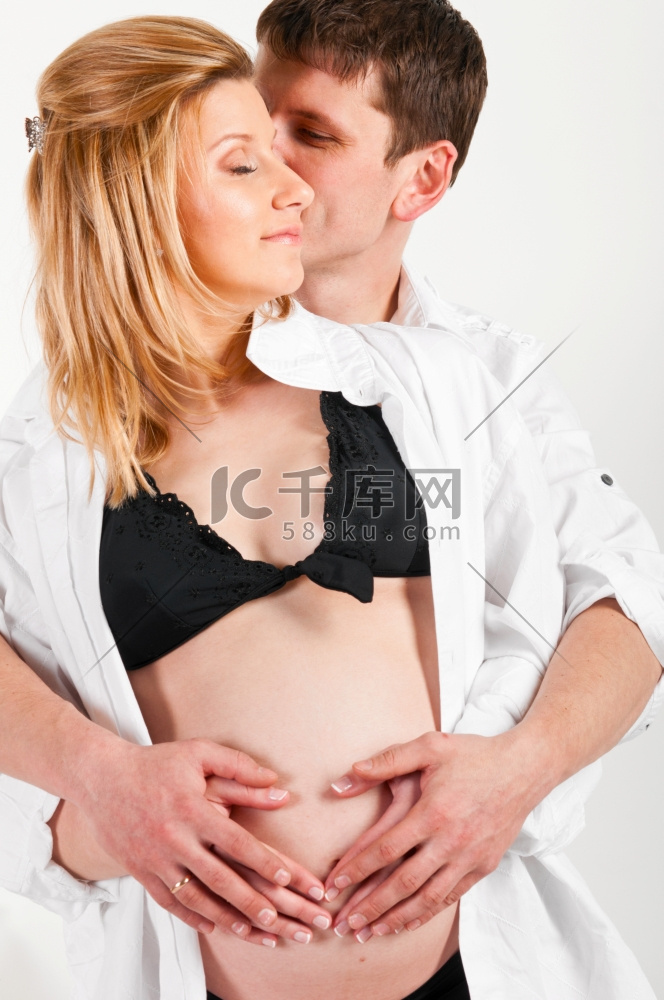 一名男子和他怀孕的妻子拥抱在一