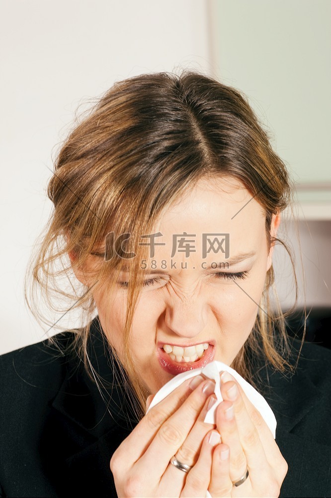 患流感或过敏的妇女对着手帕打喷
