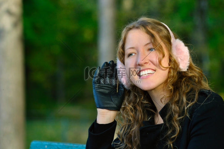 一位年轻女子正坐在秋季公园的长