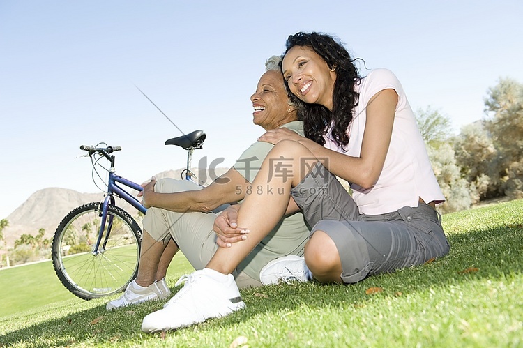 母女俩骑着山地自行车坐在公园里