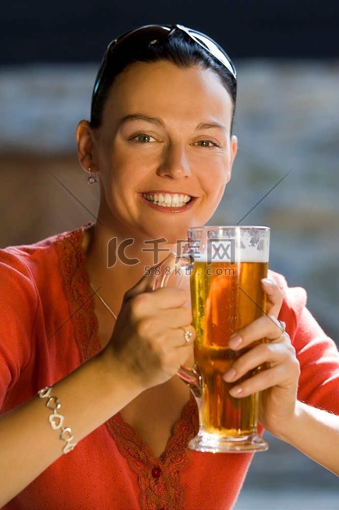 一个快乐的微笑着的年轻女子喝着