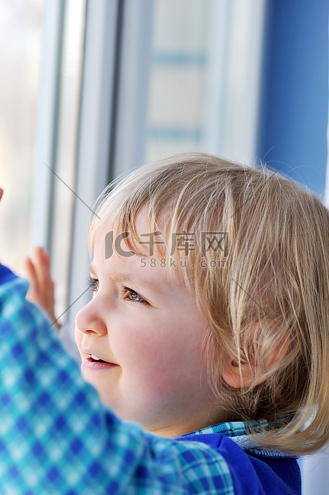 有思想的小女孩在窗前的肖像旁