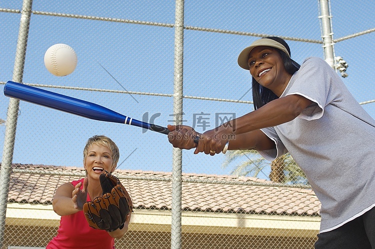 资深女子打垒球，另一名女子接球