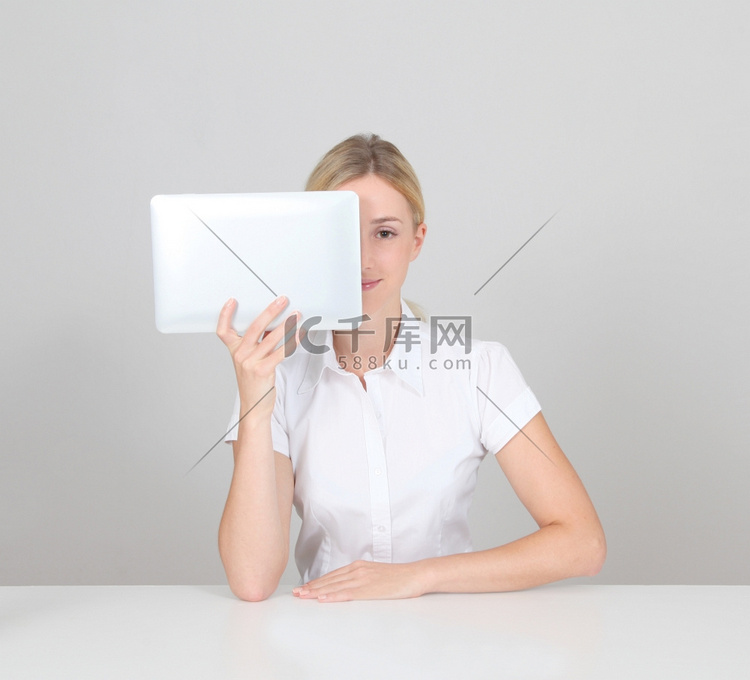 金发女子躲在电子平板电脑后面