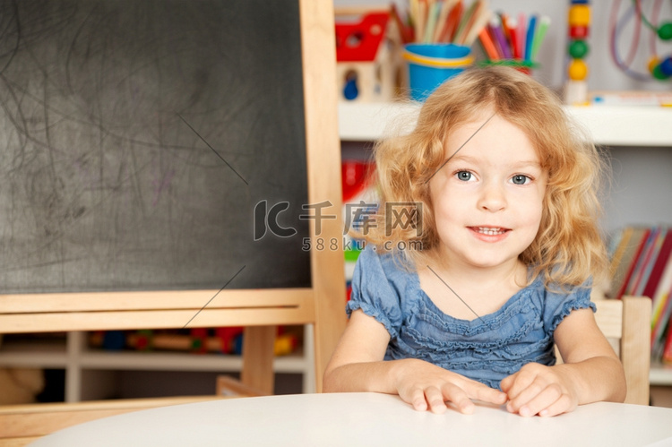 快乐的笑着的小学生在黑板上上课
