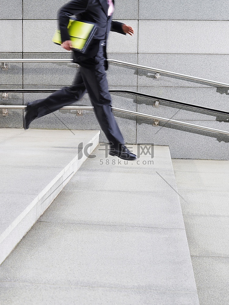 一名商人跑下台阶，从户外侧视低