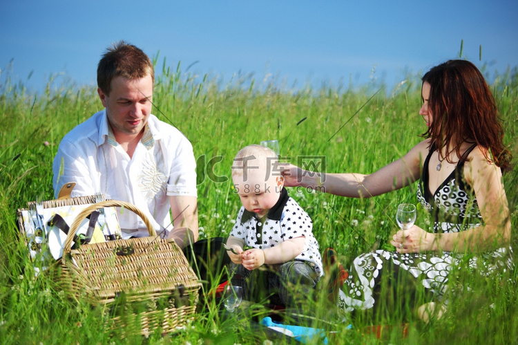 幸福的一家人在绿草如茵的野餐