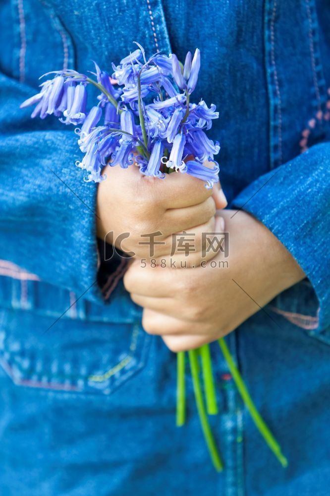 一个混血黑人小女孩手中拿着一束