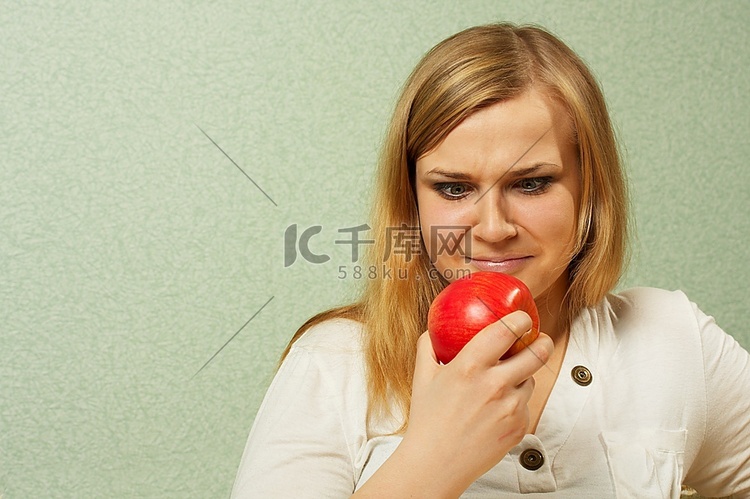 那个不满意的女孩看着一个红苹果