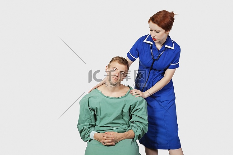 女护士在灰色背景下安慰男病人