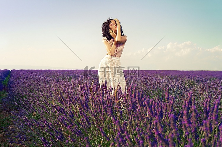 美丽迷人的女士站在一片薰衣草花