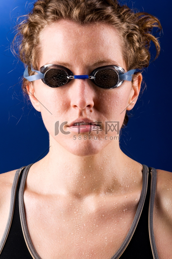 一名女游泳运动员在蓝色背景下看