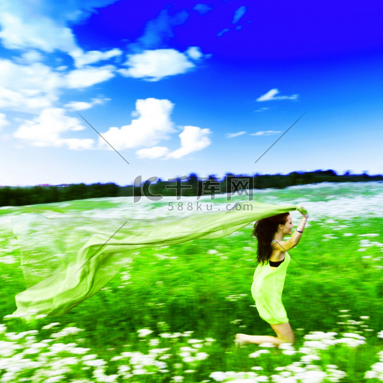 女孩在田野中奔跑，手中的布料像