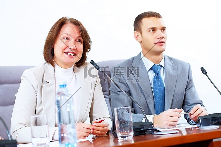 图像的两个商人坐在桌子上在会议