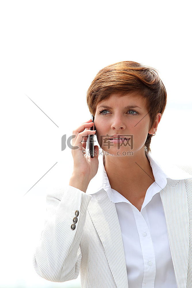 一位微笑的女商人在电话中交谈的