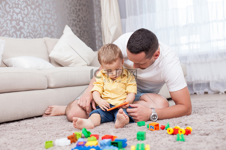 Cheerful young man is playing with his kid