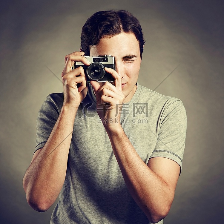 年轻男摄影师手持相机的肖像。一