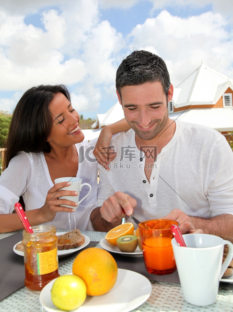 一对欢快的夫妇在户外露台上吃早