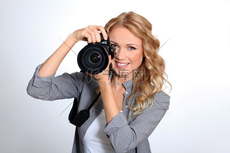 在摄影棚里使用照相相机的女性