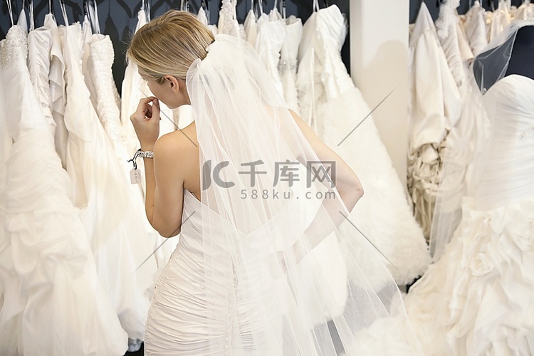 一位穿着婚纱的年轻女子看着精品