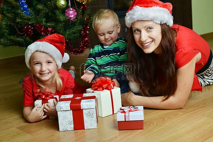 有母亲的愉快的孩子在圣诞树附近