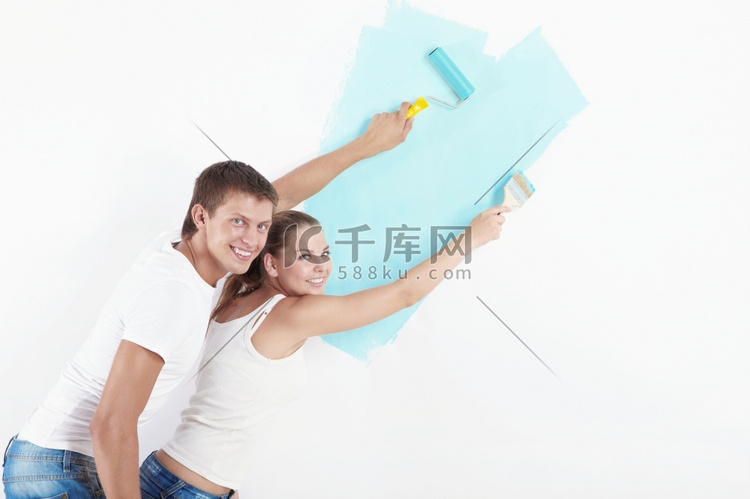 幸福的一对夫妇在家里刷墙