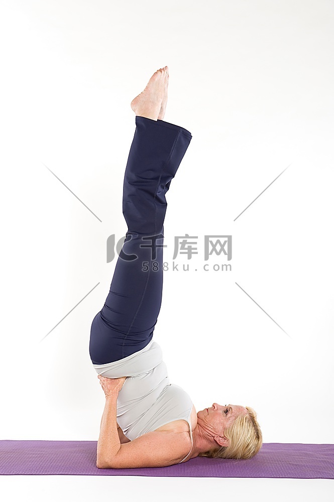 成熟女性做瑜伽姿势，双脚悬空