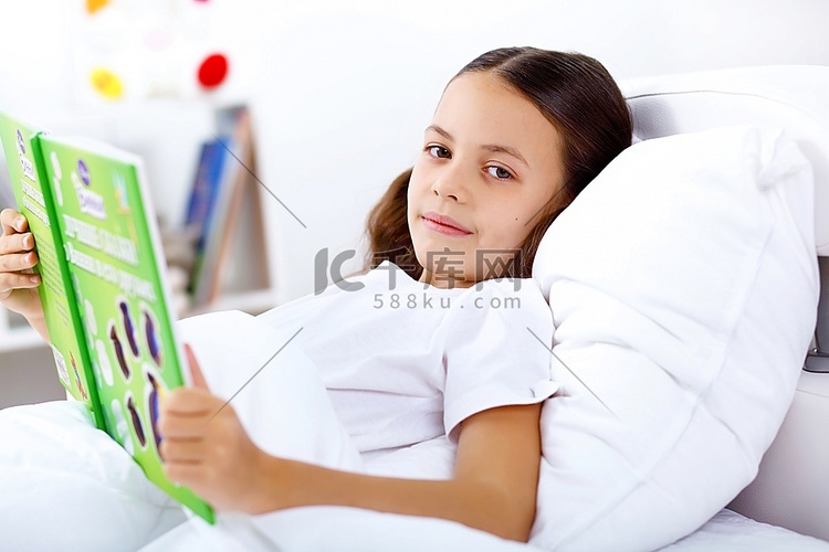 家里床上拿着一本书的女孩肖像
