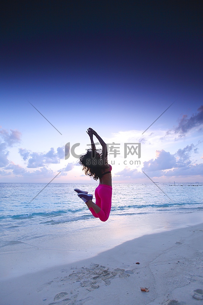 一名女子在海滩上跳跃