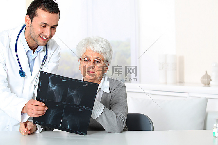 医生向老年妇女展示X光结果
