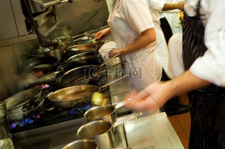 餐厅厨房的工作人员在炉子旁忙碌